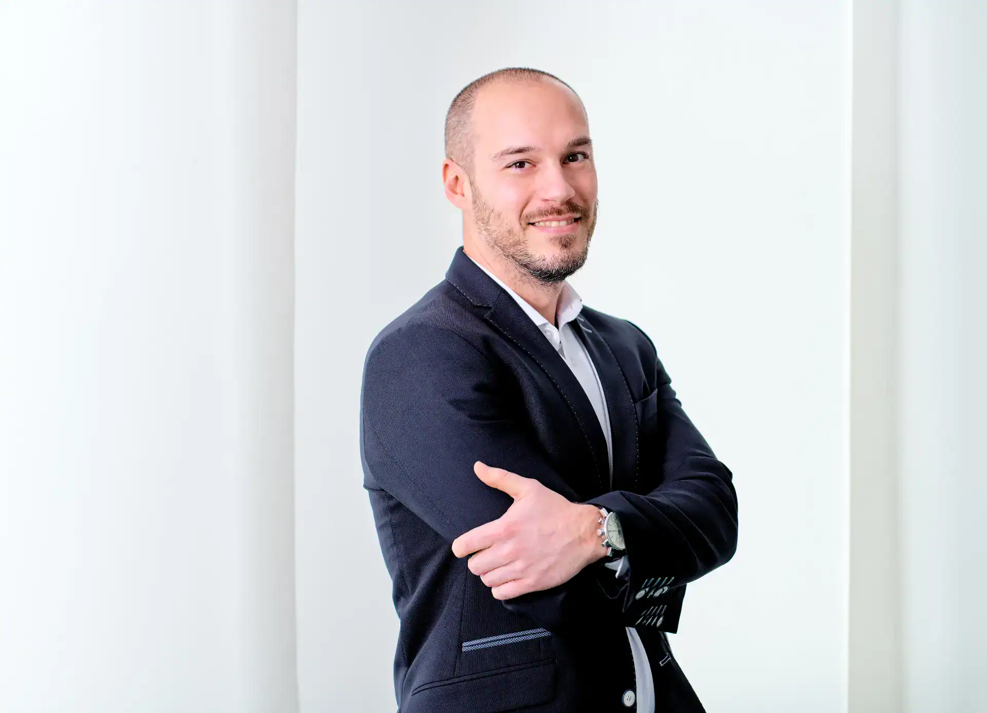 Professioneller Mann in Businesskleidung mit crossed arms, moderner Büro Hintergrund.